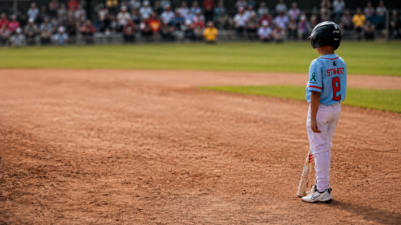 Young 5G Prime player standing on the infield with a mental health ribbon on the jersey