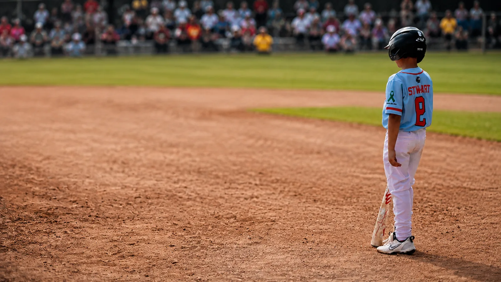 Young 5G Prime player standing on the infield with a mental health ribbon on the jersey
